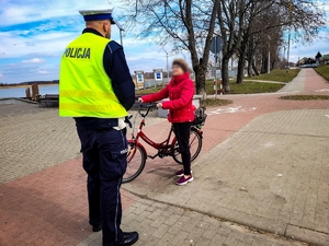 Policjant rozmawia z rowerzystką.