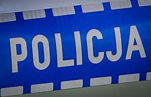 Napis policja na drzwiach radiowozu.