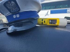 Czapka policjanta ruchu drogowego i urządzenie do badania trzeźwości.