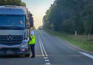 Policjantka bada trzeźwość kierowcy ciężarówki.