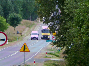 Ciężarówka wyprzedza białego busa.