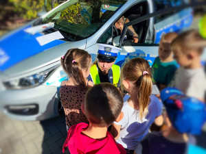 Policjanta rozmawia z dziećmi.