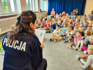 Policjantka czyta dzieciom bajkę.