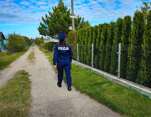 Policjantka sprawdza ogródki działkowe.