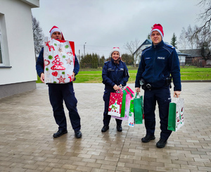Policjanci niosą prezenty.