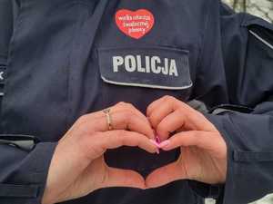 Serce ułożone z rąk za nimi serce wośp i napis policja
