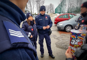 Policjanci rozmawiają z wolontariuszami WOŚP.