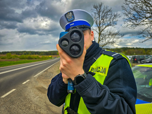 Policjant mierzy prędkość pojzadów.