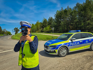 Policjantka mierzy prędkość pojazdów.