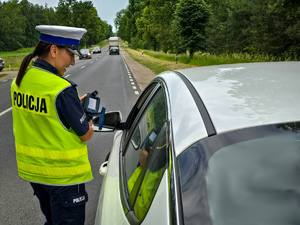 policjantka pokazuje kierowcy urządzenie do pomiaru prędkości.