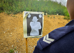 Policjantka stoi przed tarczą do strzelania.