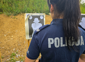 Policjantka stoi przed tarczą do strzelania.