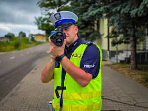 Policjant mierzy prędkość pojazdów.