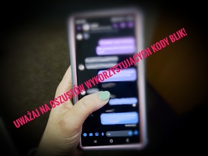 Kobieta trzyma telefon w ręku, napis Uważaj na oszustów wykorzystujących kody BLIK.