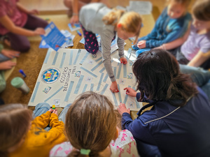 Policjantka z dziećmi tworzy plakat