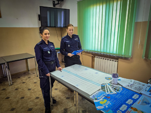 Policjanci rozwiązują z dziećmi krzyżówkę.