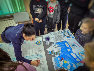 Policjanci rozwiązują z dziećmi krzyżówkę.