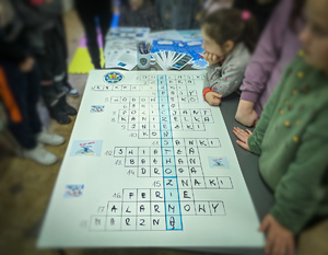 Policjanci rozwiązują z dziećmi krzyżówkę.