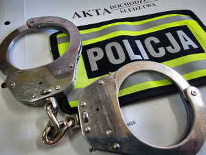 Naszywka policyjna i kajdanki na teczce z aktami