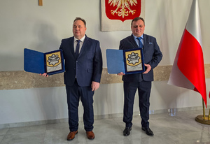 Emerytowani policjanci z pamiątkowymi tablicami