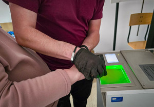 Policjant pobiera od kobiety odciski palców