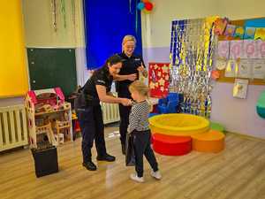 Policjantki wręczają dzieciom nagrody.