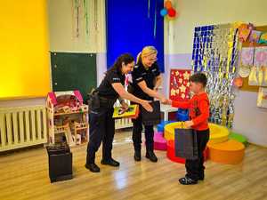 Policjantki wręczają dzieciom nagrody.