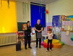 Policjantki wręczają dzieciom nagrody.