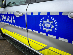 Napis policja, gwiazda policyjna i napis pomagamy i chronimy 112 na radiowozie.