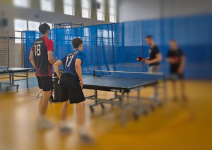 Mężczyźni grają w tenisa stołowego.