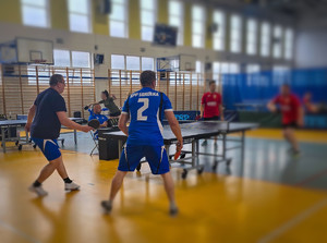 Mężczyźni grają w tenisa stołowego.