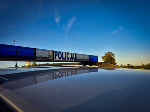 Światła błyskowe samochodu i napis Policja.