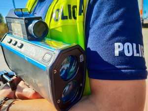 policjant z urządzeniem do mierzenia prędkości.