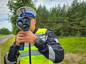 Policjant mierzy prędkość pojazdów.