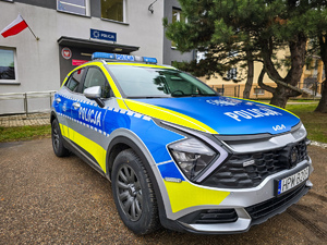 Policyjny radiowóz, w tle posterunek