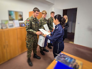 Policjantki wręczają nagrody uczniom w mundurach.