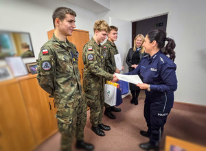 Policjantki wręczają nagrody uczniom w mundurach.