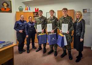 Policjantki wręczają nagrody uczniom w mundurach.