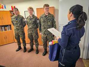 Policjantki wręczają nagrody uczniom w mundurach.