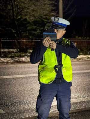 Policjant mierzy prędkość pojazdów.
