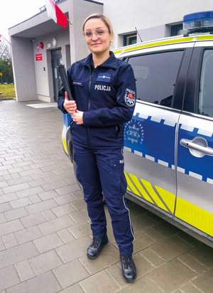 Policjantka z teczką przy radiowozie