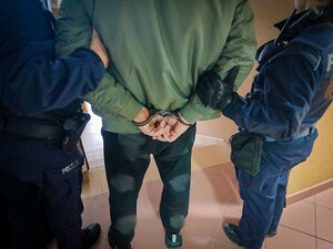 Mężczyzna w kajdankach z policjantami