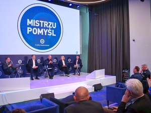 Ludzie na scenie w tle napis Mistrzu Pomyśl