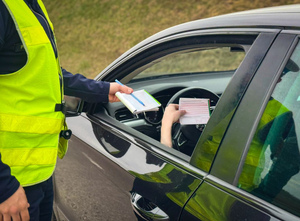 Policjant podaje bloczek mandatowy kierowcy