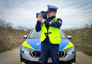 Policjant mierzy prędkość pojazdów.
