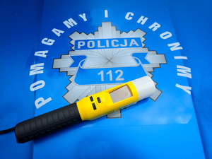 Gwiazda policyjna i napis Pomagamy i Chronimy i urządzenie do badania trzeźwości.